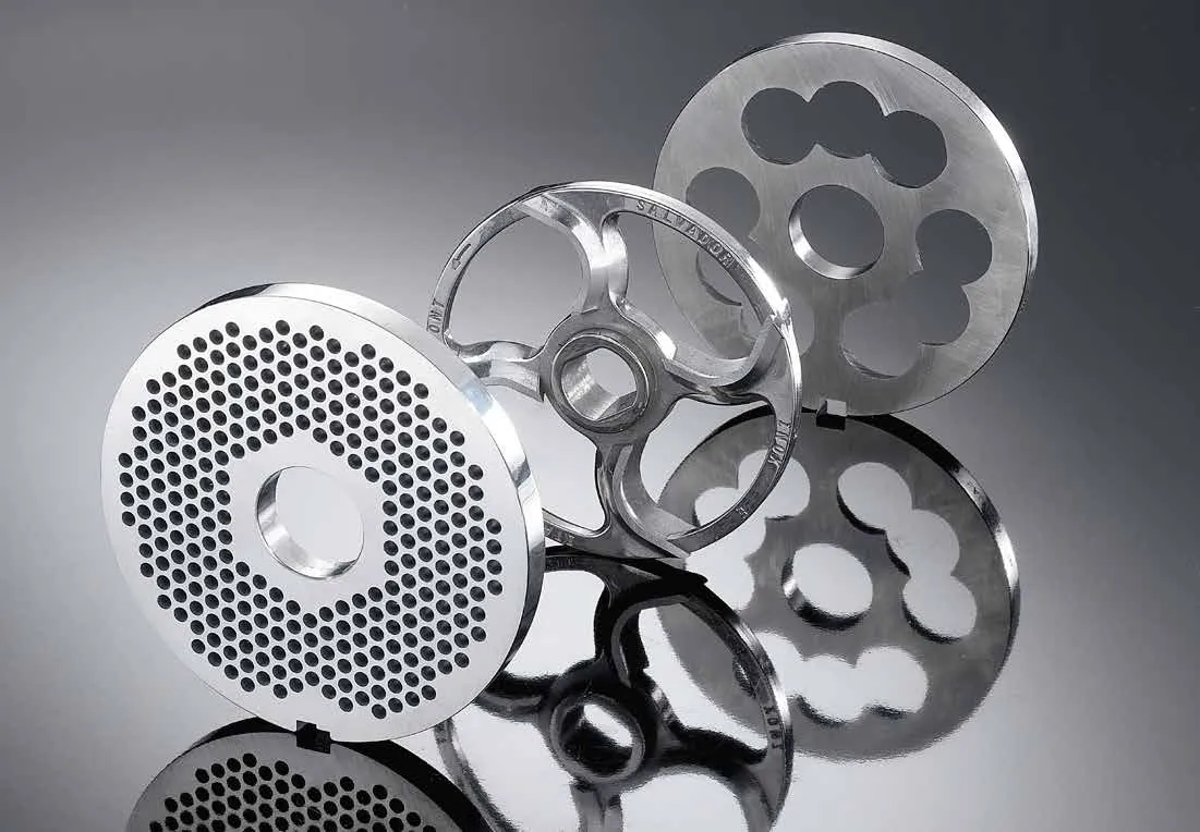 Mincer plates and cutting parts arranged on a dark surface