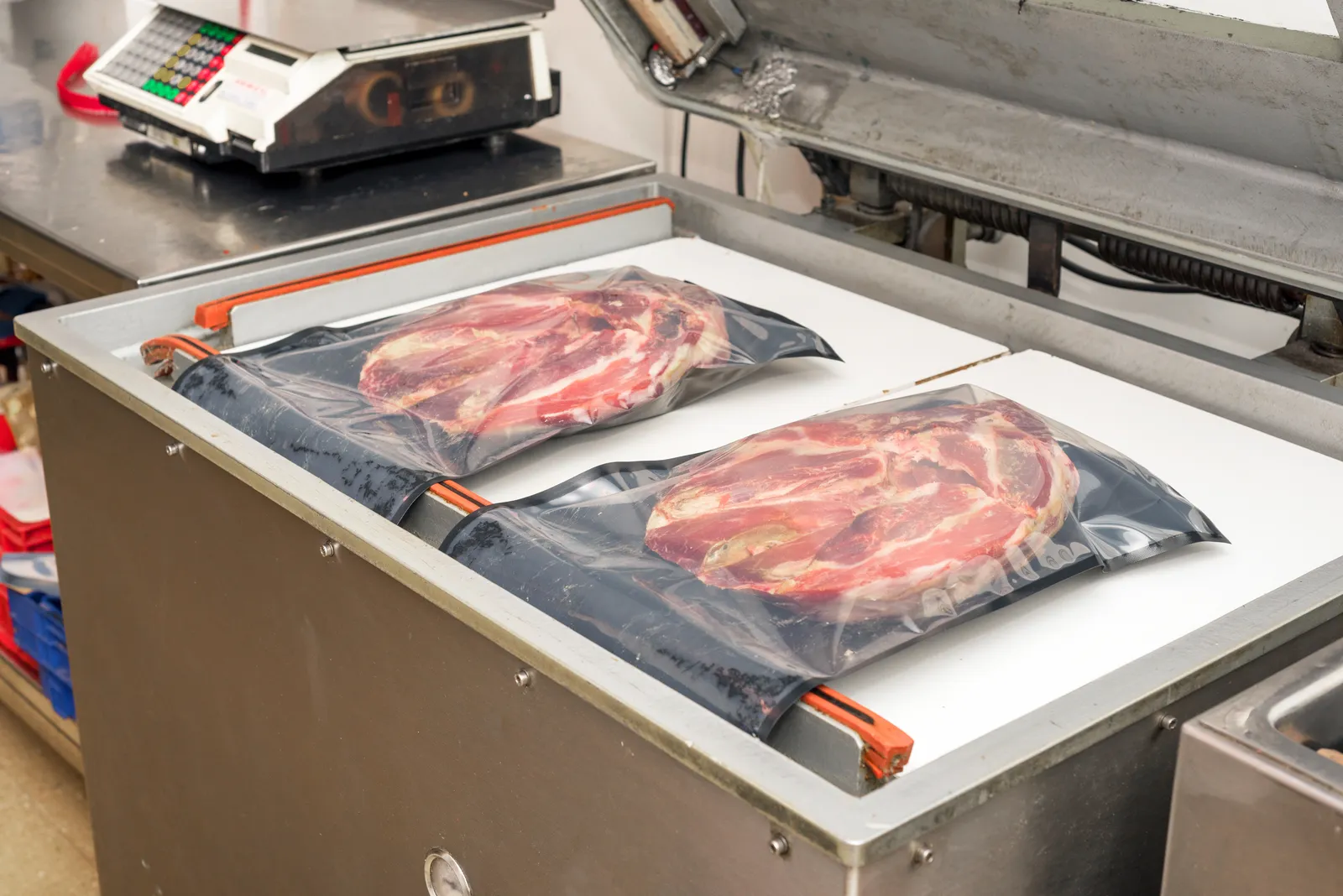Vacuum sealing equipment in a food-processing line